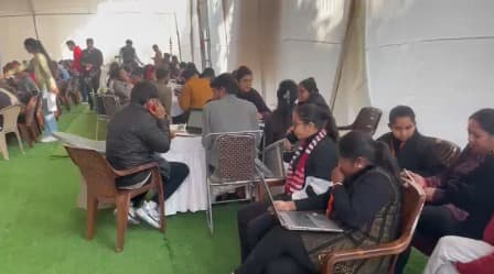 Campaign volunteers and field teams working on laptops inside a booth-day war room
